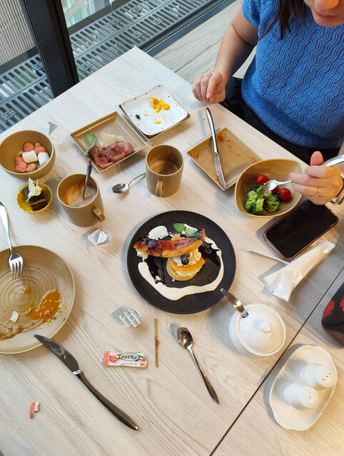 Buffet frente al ventanal: panqueques con banana caramelizada y crema, jamon, brocoli con tomates, tartitas y cafe con leche.